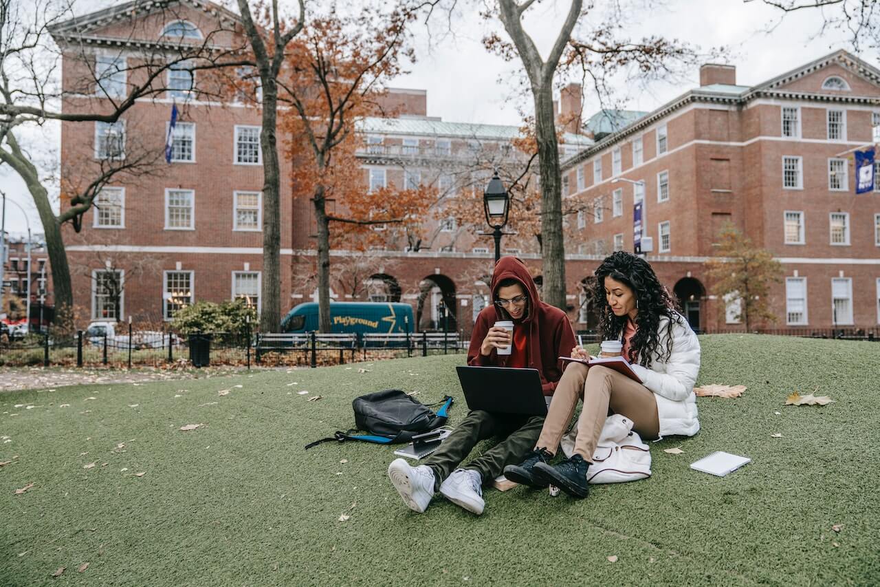 Students sat on grass outside university accommodation 